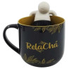 Caneca de cermica com o nome "RelaCh" em dourado, decorada com folhas ao redor. A caneca vem com um mini boneco que se encaixa na borda, proporcionando um design nico e relaxante, ideal para quem aprecia ch e momentos de tranquilidade.