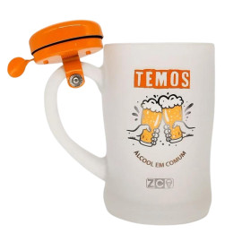 Caneca de vidro para chopp com tampa laranja, com a frase "TEMOS LCOOL EM COMUM" e ilustrao de duas canecas de cerveja brindando.